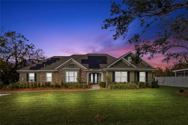 view of front of house with a lawn and solar panels