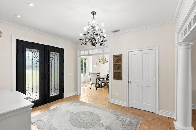 tiled entrance foyer featuring a chandelier, decorative columns, and ornamental molding