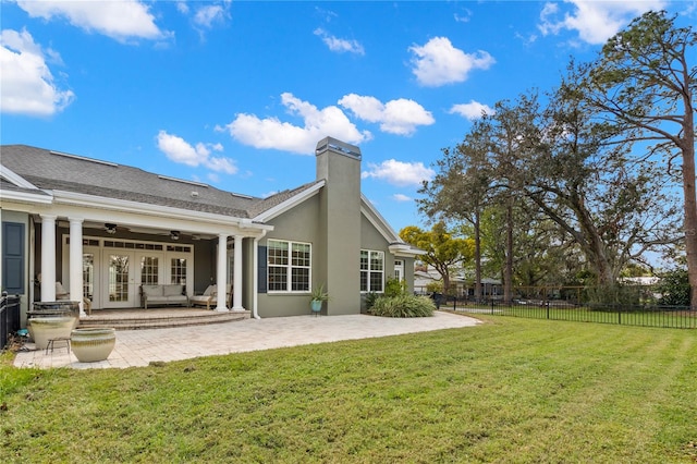 rear view of house featuring a lawn, ceiling fan, a patio area, and french doors