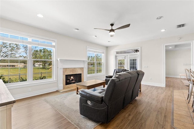 living room featuring ceiling fan, a healthy amount of sunlight, wood-type flooring, and french doors