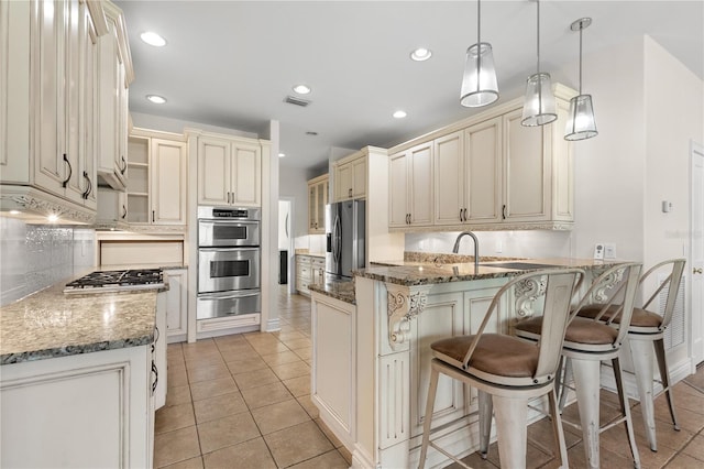 kitchen with kitchen peninsula, a kitchen breakfast bar, dark stone counters, stainless steel appliances, and pendant lighting