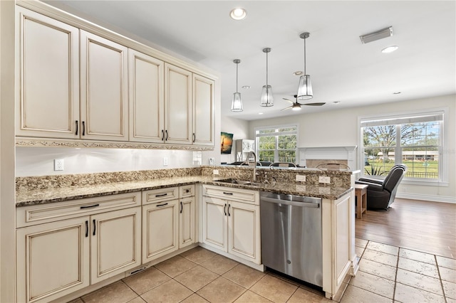 kitchen with kitchen peninsula, ceiling fan, sink, cream cabinetry, and dishwasher