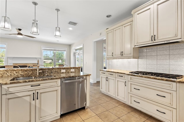 kitchen featuring pendant lighting, cream cabinets, stainless steel appliances, and plenty of natural light