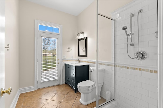 bathroom featuring tile patterned flooring, a tile shower, vanity, and toilet