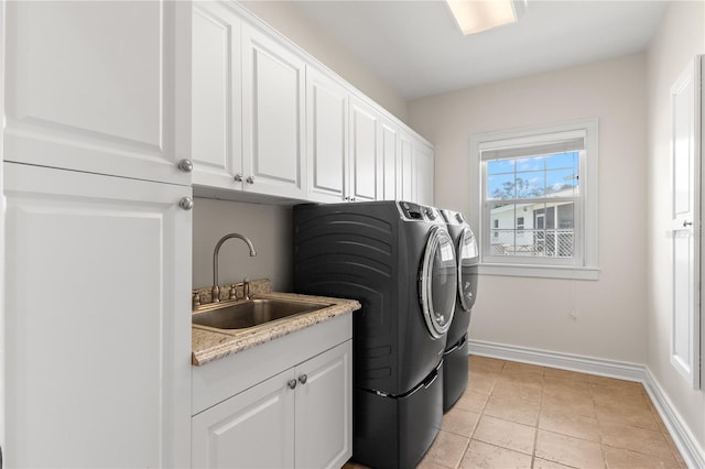 laundry area featuring cabinets, light tile patterned floors, washing machine and dryer, and sink