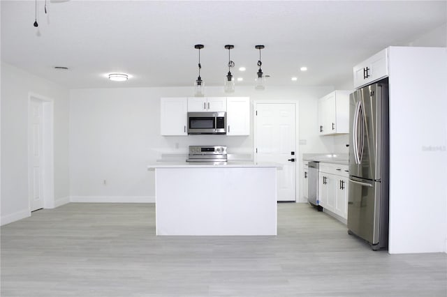 kitchen with pendant lighting, a center island, white cabinets, and appliances with stainless steel finishes