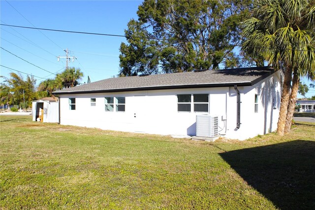 view of side of property featuring a yard and central air condition unit