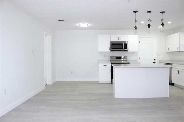 kitchen featuring white cabinetry, stainless steel appliances, light hardwood / wood-style flooring, decorative light fixtures, and a kitchen island