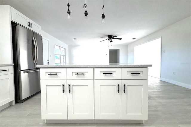 kitchen with stainless steel fridge, light wood-type flooring, white cabinetry, and ceiling fan