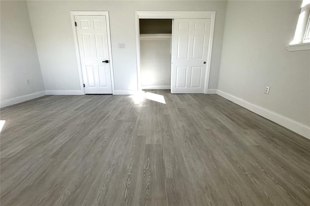 unfurnished bedroom featuring a closet and dark wood-type flooring