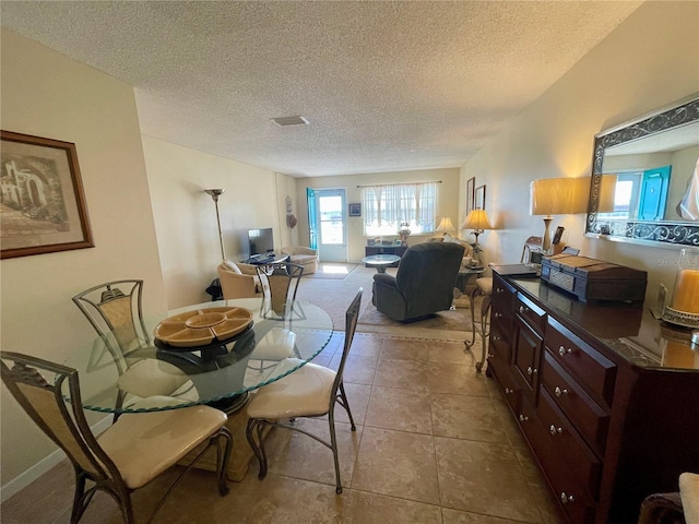 tiled dining area with a textured ceiling