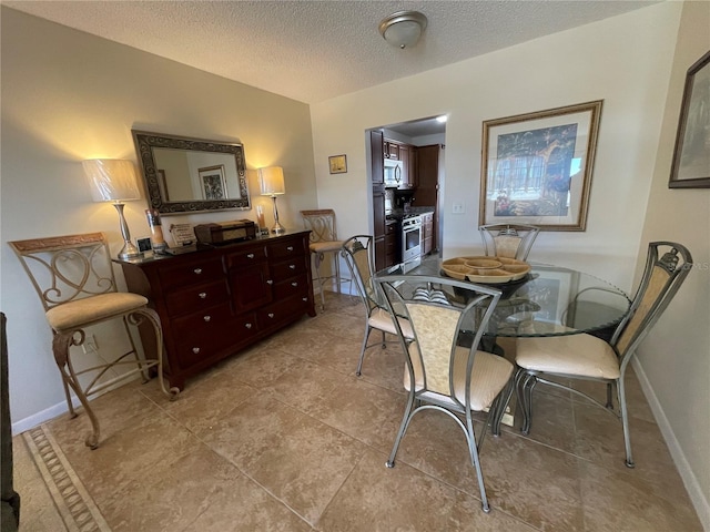 dining room with light tile patterned floors and a textured ceiling