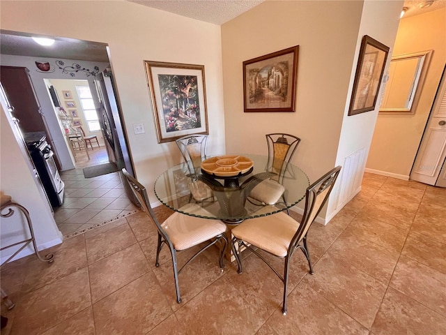 dining room with light tile patterned flooring and a textured ceiling