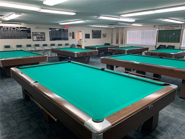 game room featuring pool table, a textured ceiling, and dark colored carpet