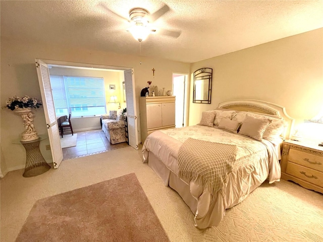 bedroom with ceiling fan, light tile patterned floors, and a textured ceiling