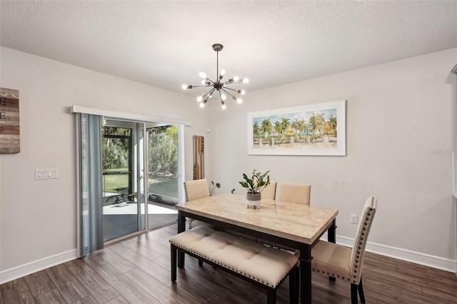 dining room featuring hardwood / wood-style floors, a textured ceiling, and a chandelier