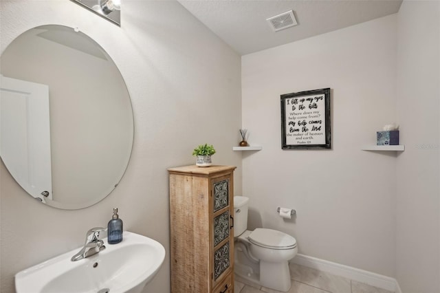 bathroom with toilet, tile patterned floors, and sink