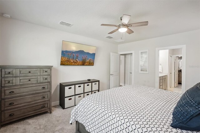 bedroom featuring light carpet, connected bathroom, and ceiling fan