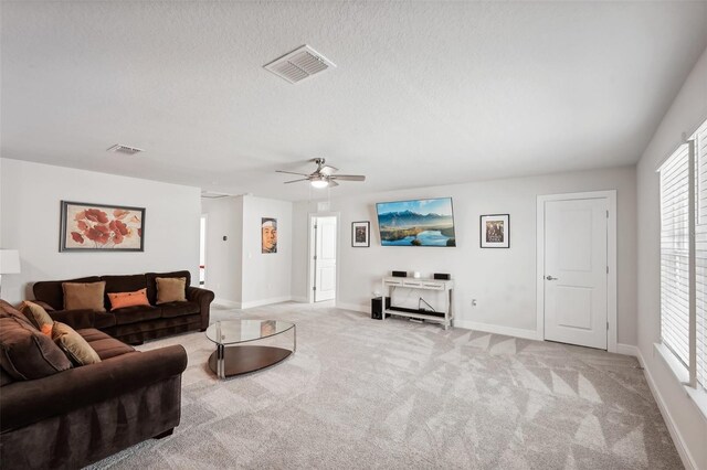 carpeted living room featuring ceiling fan, a textured ceiling, and a wealth of natural light