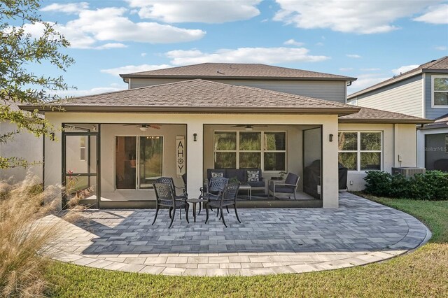 rear view of house with ceiling fan, a patio area, an outdoor living space, and central AC