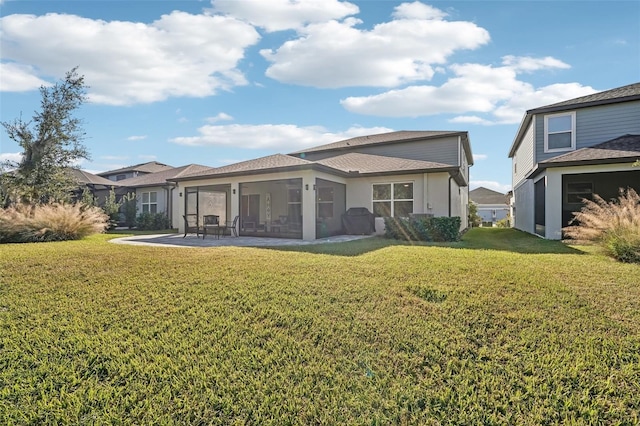 back of house featuring a sunroom and a lawn