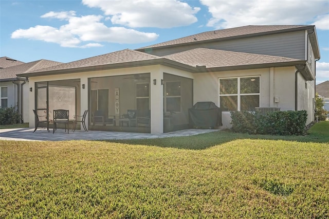 rear view of house featuring a yard, a patio area, and a sunroom