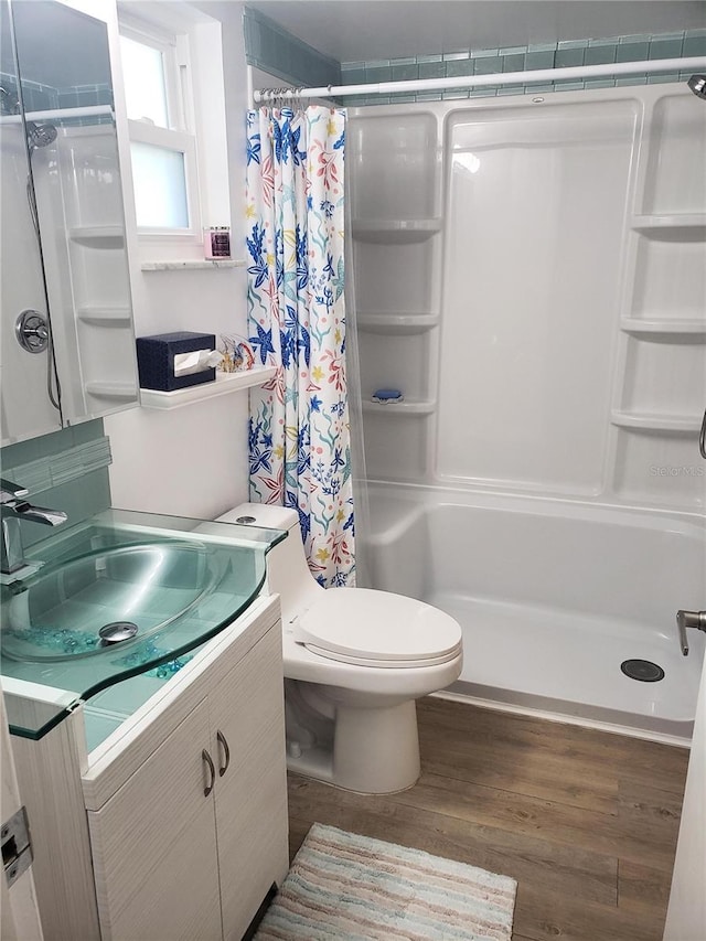 bathroom with vanity, hardwood / wood-style flooring, toilet, and walk in shower