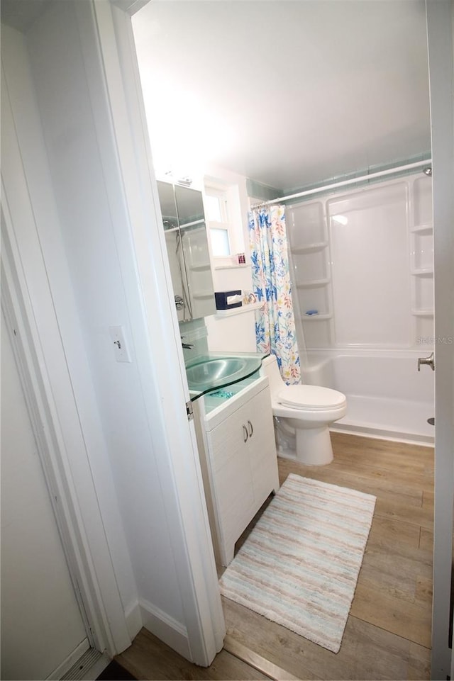 bathroom featuring vanity, hardwood / wood-style flooring, toilet, and walk in shower