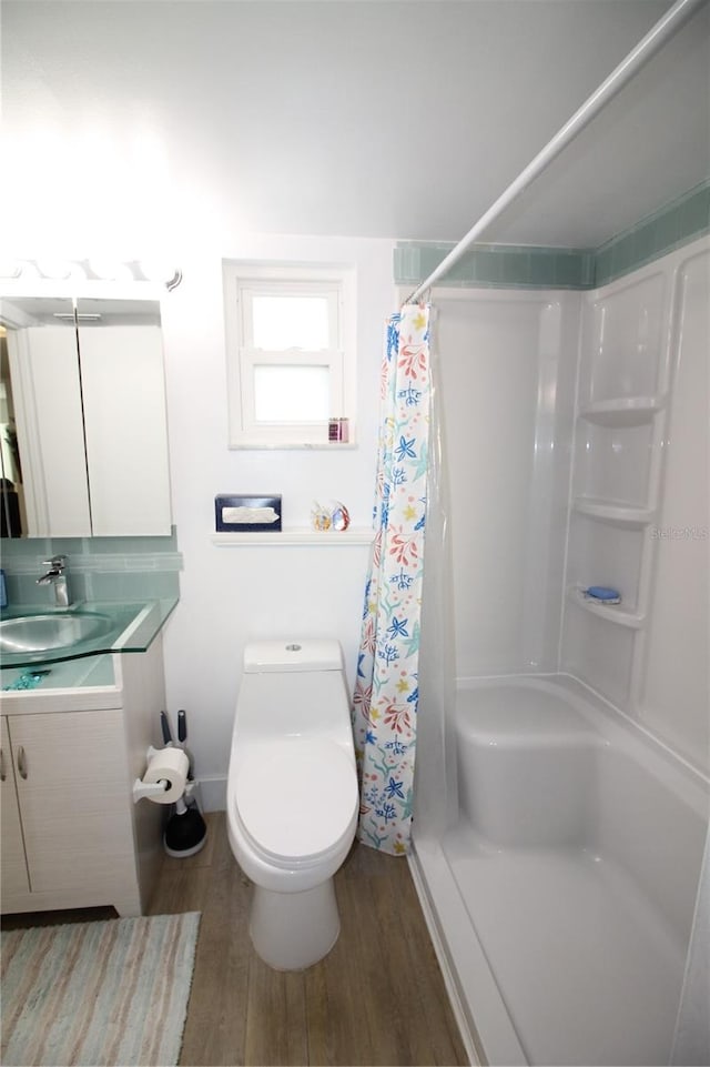 bathroom featuring a shower with curtain, toilet, wood-type flooring, and vanity