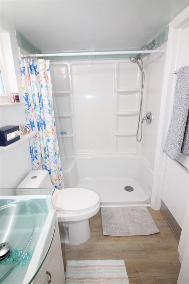 bathroom featuring walk in shower, toilet, vanity, and hardwood / wood-style flooring