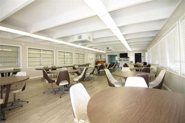 dining room with beamed ceiling and light hardwood / wood-style floors