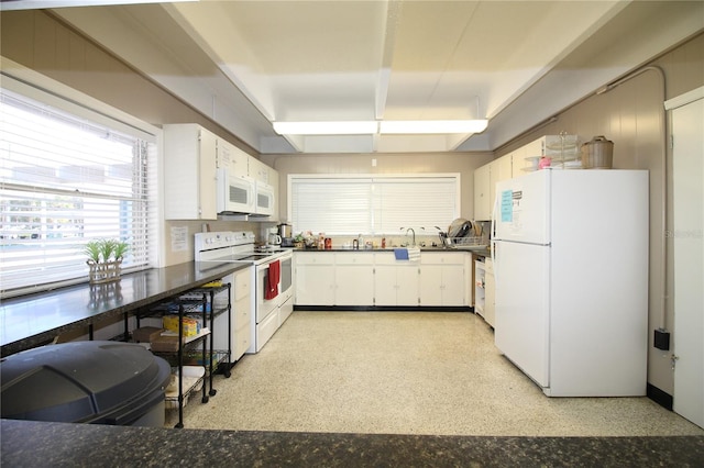 kitchen with white appliances, white cabinetry, and sink