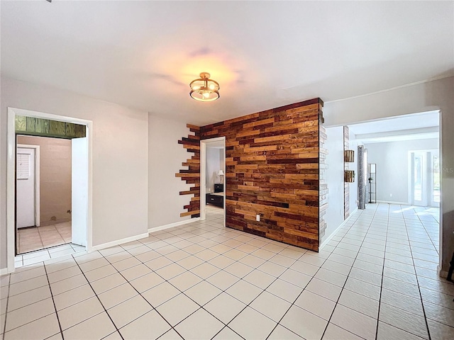 tiled spare room featuring wood walls