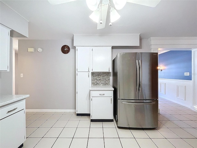 kitchen featuring stainless steel refrigerator, white cabinetry, ceiling fan, and decorative backsplash