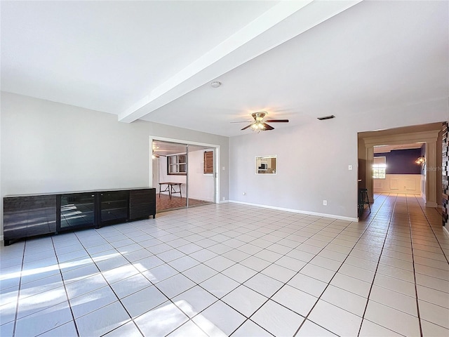 unfurnished living room featuring ceiling fan, beam ceiling, and light tile patterned flooring