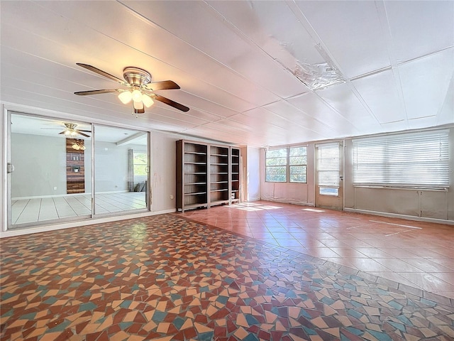 unfurnished living room featuring tile patterned flooring, built in features, and ceiling fan