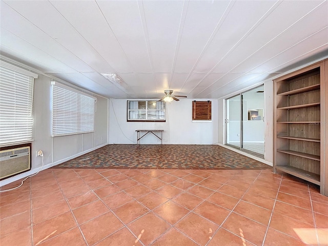 tiled spare room with ceiling fan, built in features, and an AC wall unit