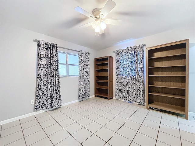 empty room with ceiling fan and light tile patterned floors