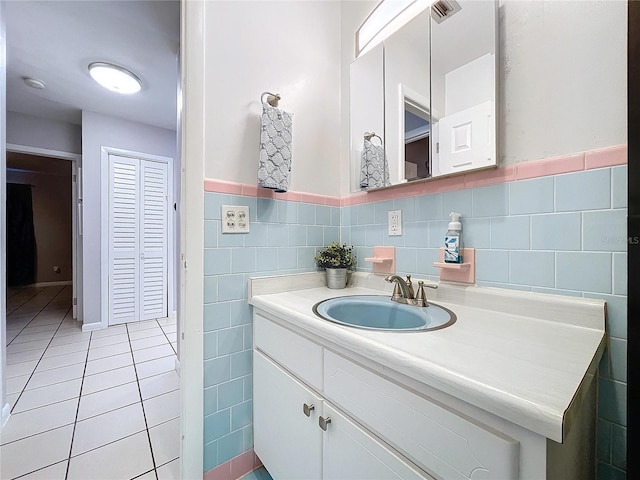 bathroom with tile patterned floors, vanity, and tile walls