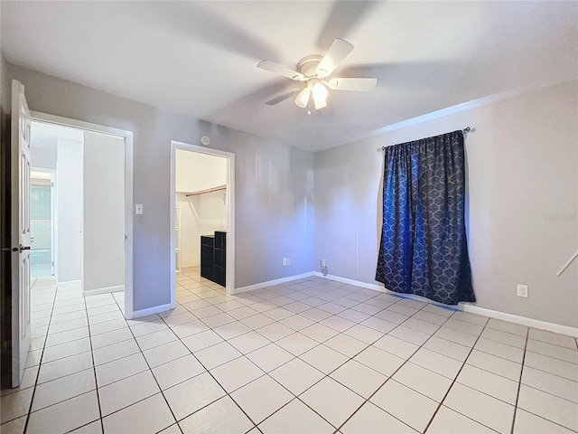 empty room with ceiling fan and light tile patterned flooring