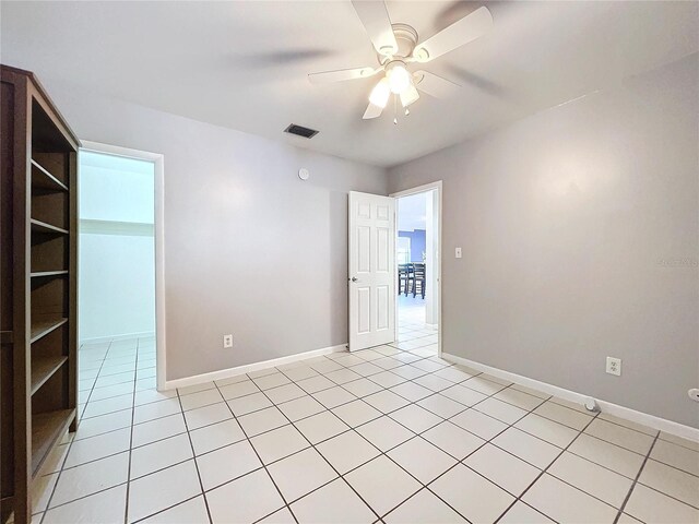 tiled spare room with ceiling fan