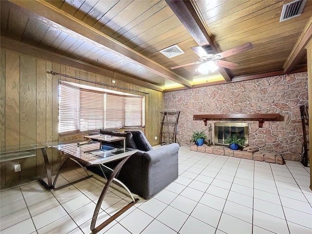 living room featuring beamed ceiling, light tile patterned flooring, wooden ceiling, and a fireplace