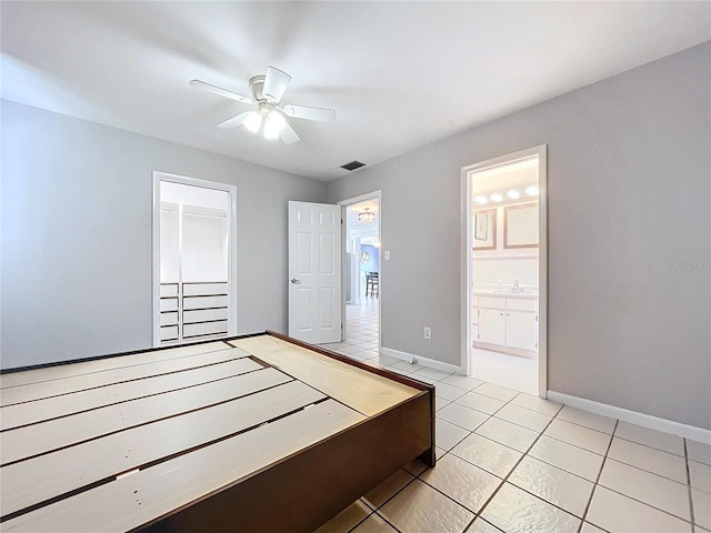 bedroom featuring ceiling fan, sink, connected bathroom, a closet, and light tile patterned flooring