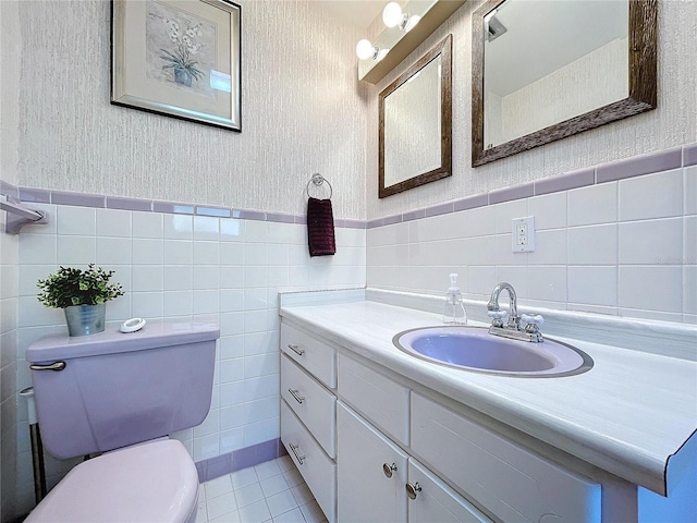 bathroom featuring tile patterned floors, vanity, tile walls, and toilet