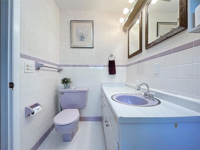 bathroom featuring tile patterned flooring, vanity, toilet, and tile walls