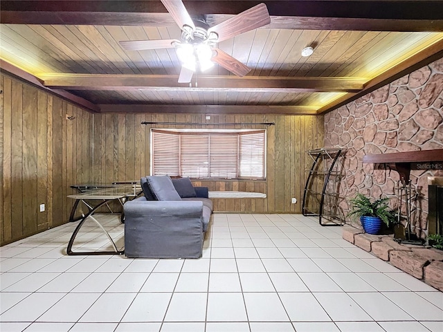 sitting room with wood ceiling, ceiling fan, wooden walls, beamed ceiling, and light tile patterned flooring