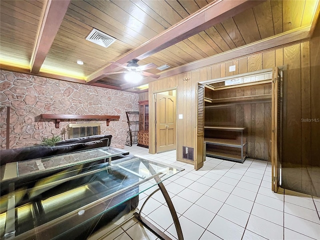 kitchen with beamed ceiling, wood walls, light tile patterned flooring, and wooden ceiling