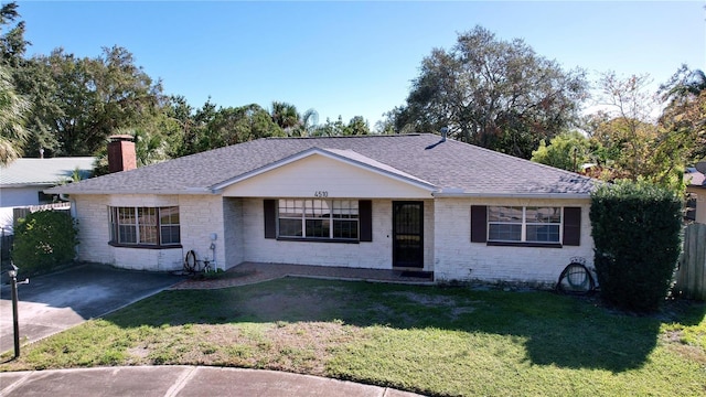 ranch-style house with a carport and a front lawn