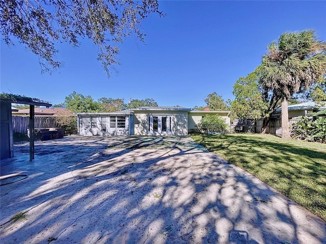 ranch-style house featuring a front yard and a patio