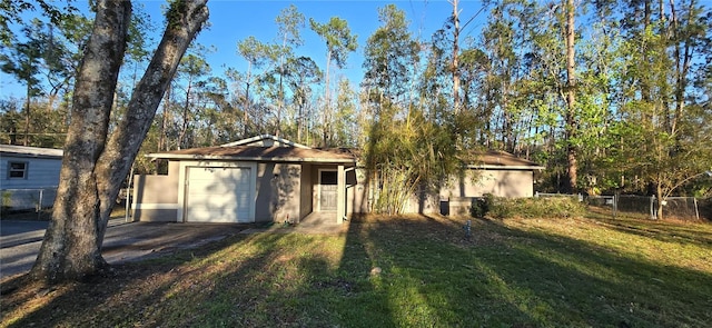 view of front of house with stucco siding, a front yard, fence, a garage, and driveway